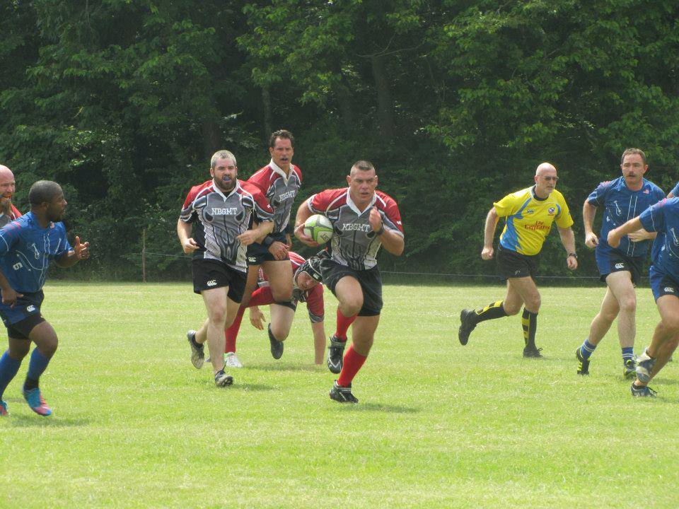 Men playing rugby on field