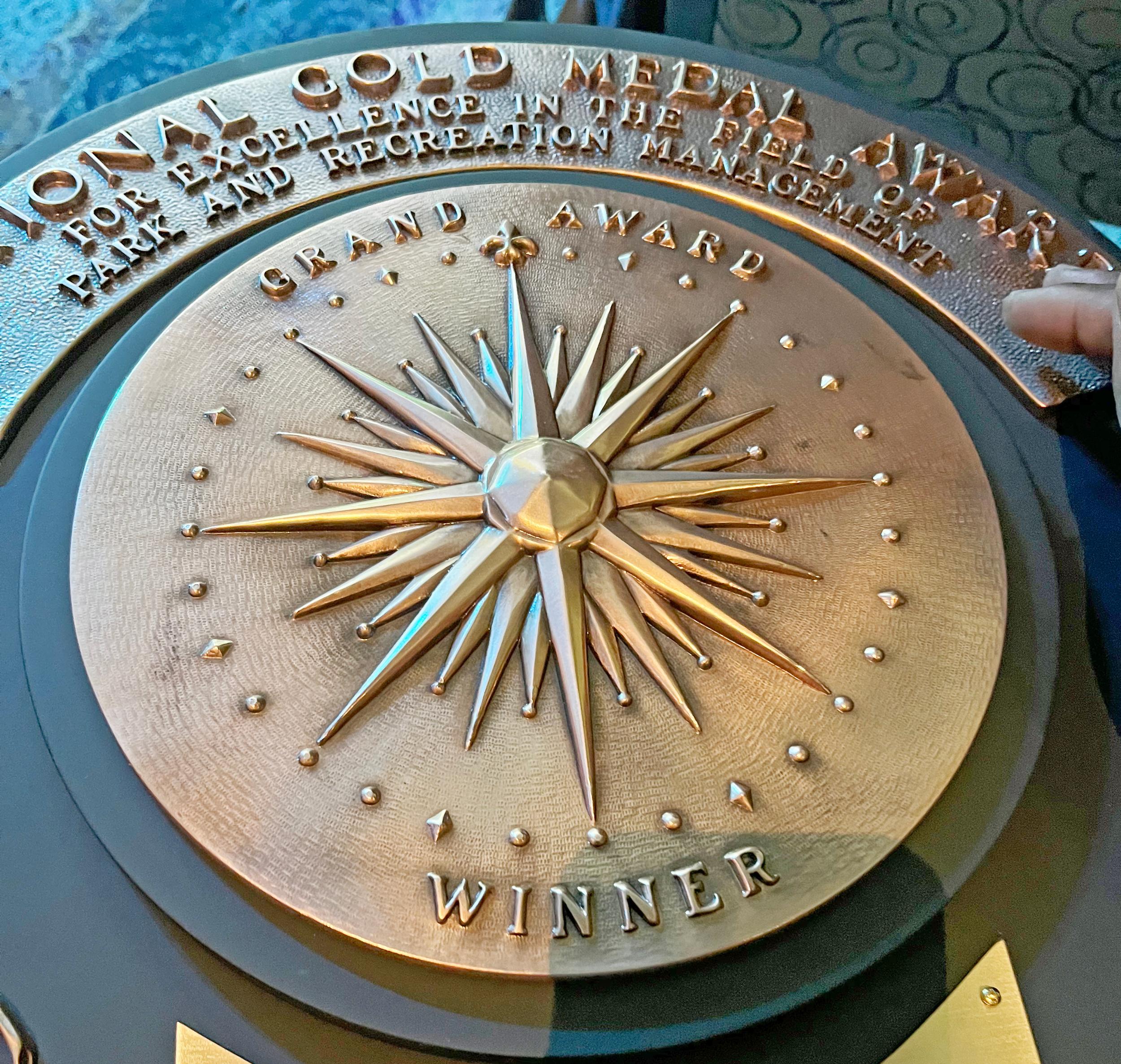 Close-up of gold medal winner plaque with metal engravings