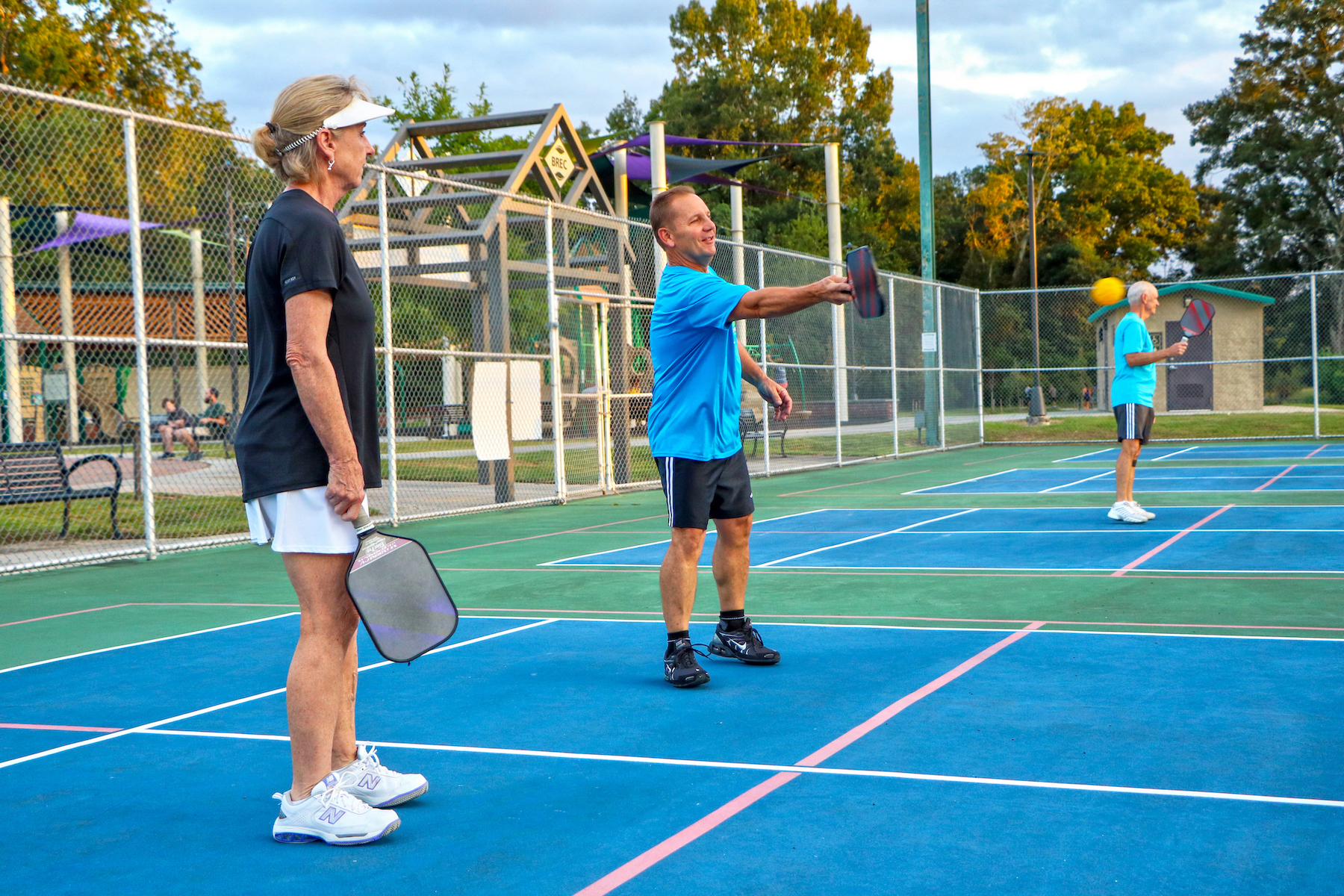 Group of people playing pickleball on an outdoor court