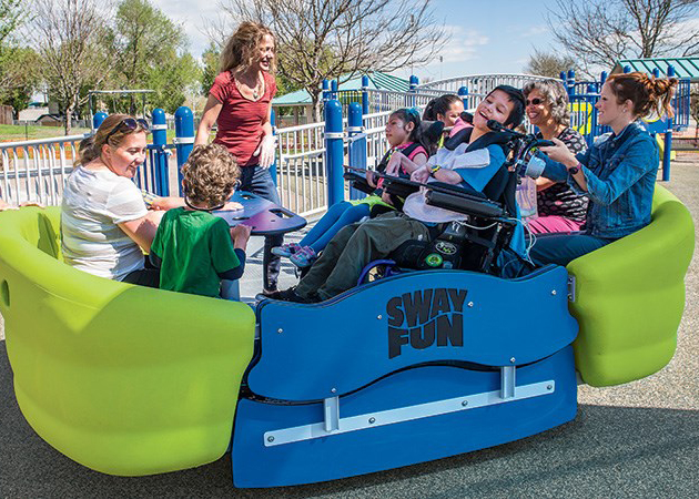 Children with and without disabilities play on glider.