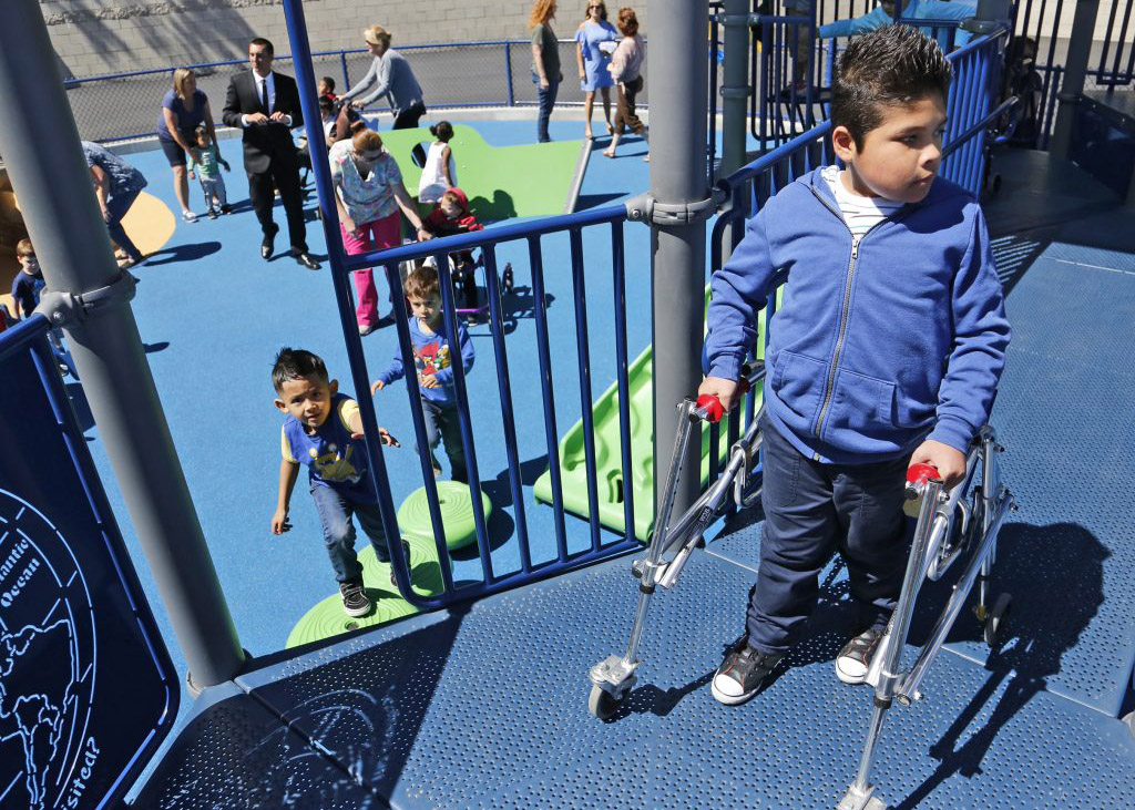 Child with mobility device standing on elevated deck