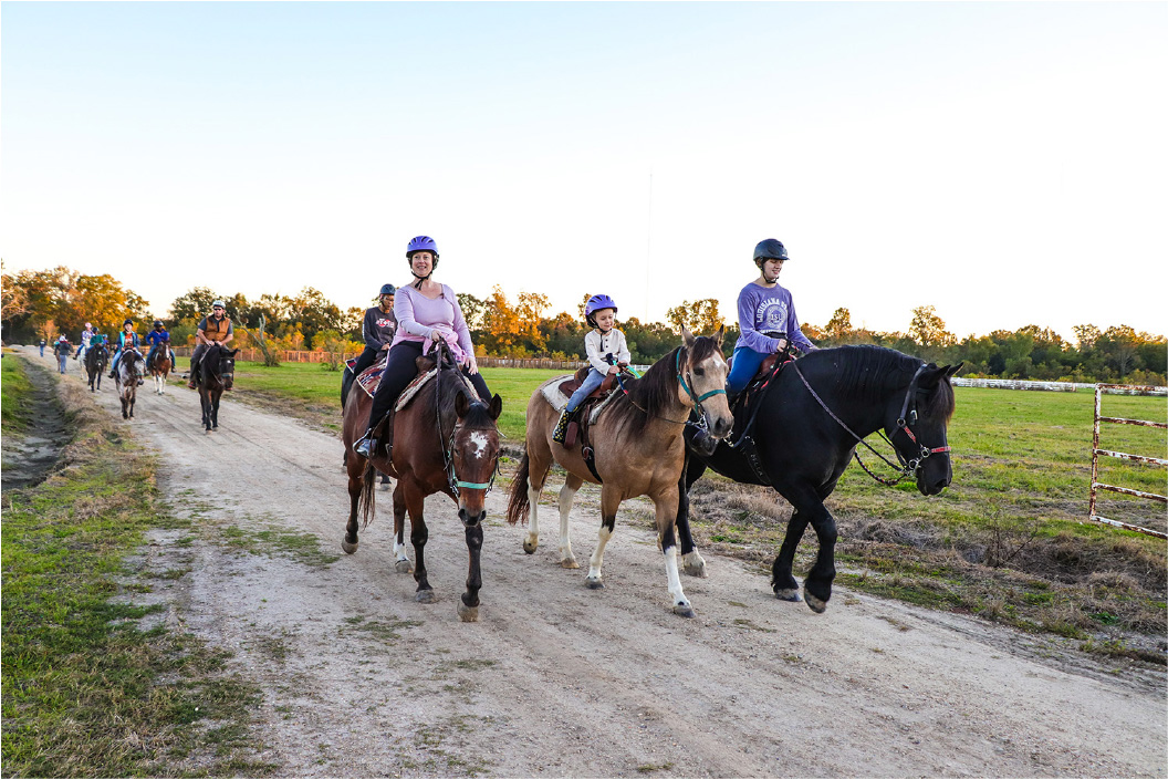 Group of people riding horses on trail